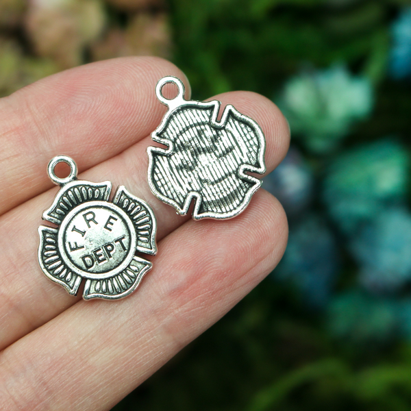 Small silver tone charms in the shape of the Maltese Cross and marked "FIRE DEPT" on the front.
