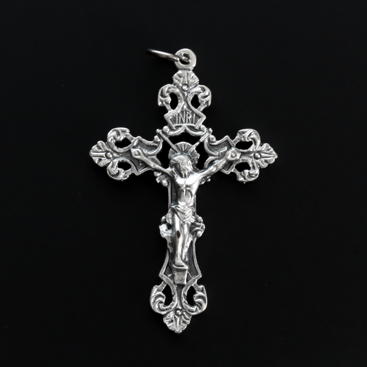 Ornate fleur de lis crucifix cross in an antiqued silver-tone color and filigree cut out design.