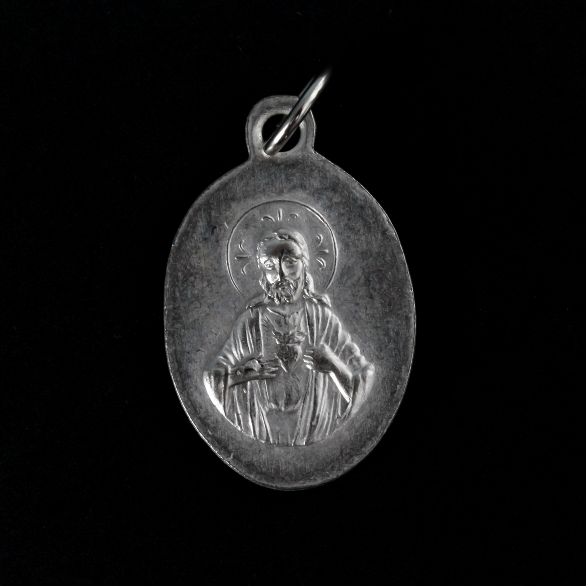 Our Lady of San Juan de Los Lagos medal that depicts the image of Our Lady on the front and the Sacred Heart of Jesus on the back