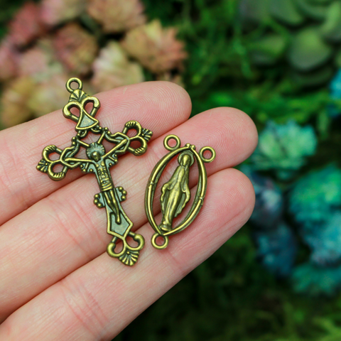 Bronze rosary set that includes a Virgin Mary centerpiece with a cut-out design and an ornate crucifix cross.
