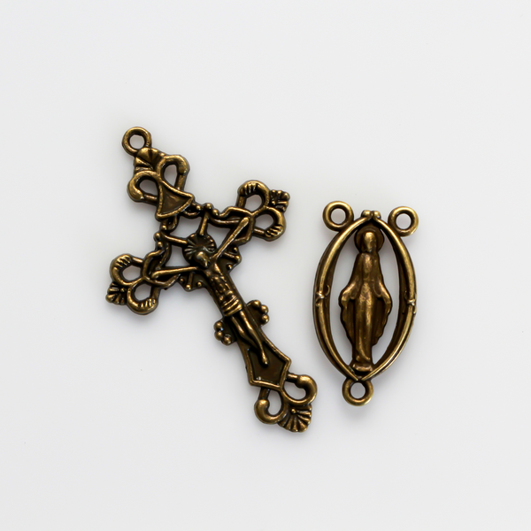 Bronze rosary set that includes a Virgin Mary centerpiece with a cut-out design and an ornate crucifix cross.