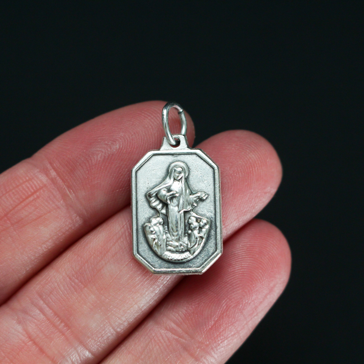 Unique shaped medal with Our Lady of Medjugorje on the front and St. James Church on the back.