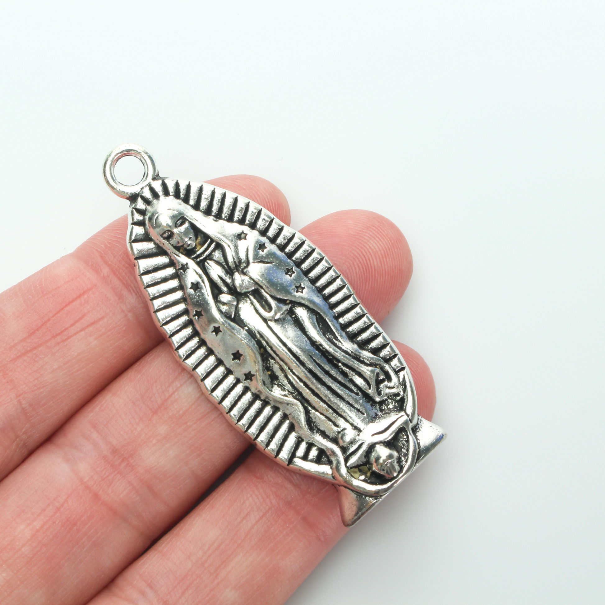 A beautifully detailed pendant of Our Lady of Guadalupe. This large charm is two inches long with a flat, plain back