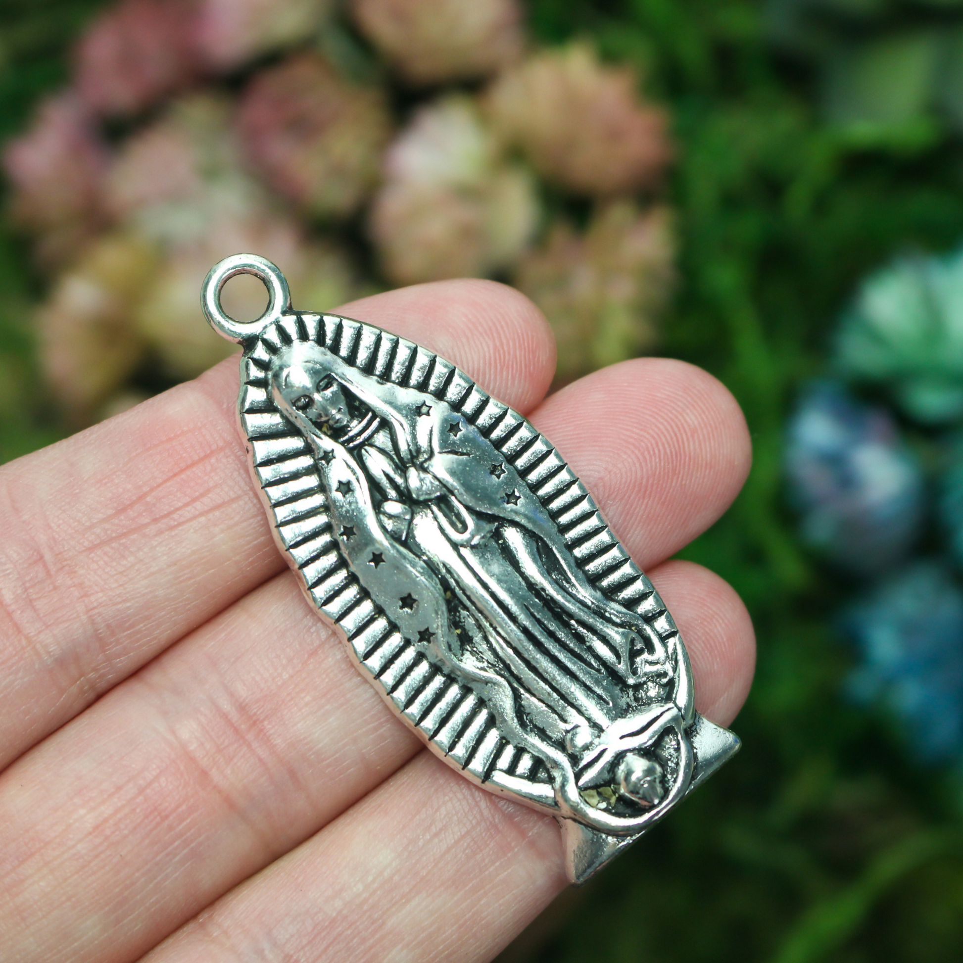 A beautifully detailed pendant of Our Lady of Guadalupe. This large charm is two inches long with a flat, plain back