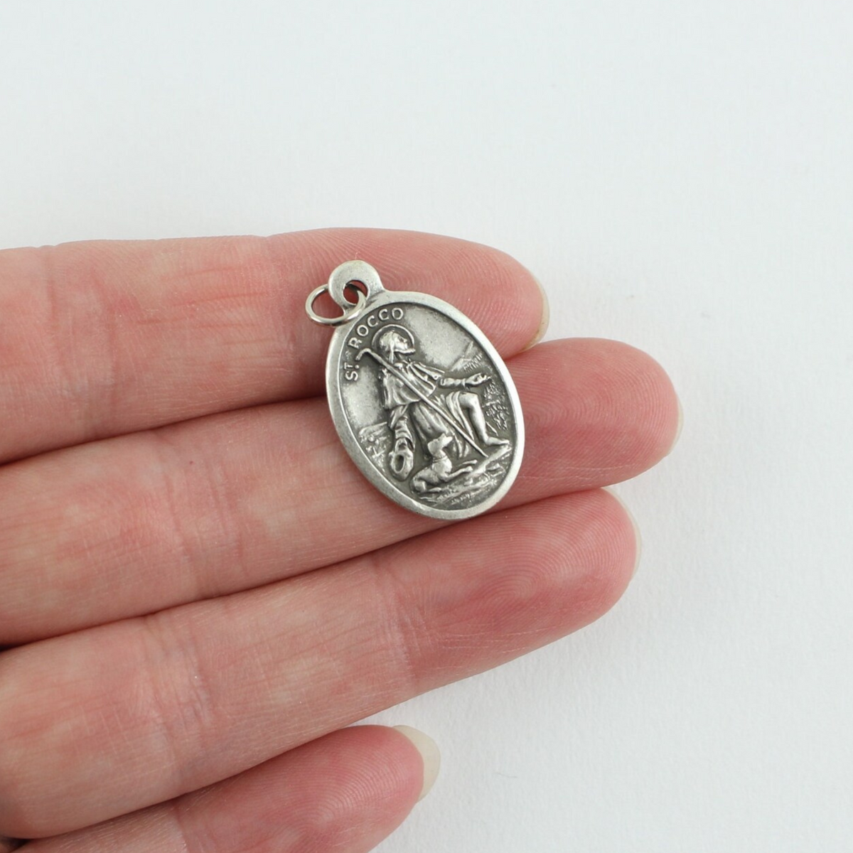 Saint Rocco (Roch) oval medal that depicts the saint on the front and "Pray For Us" on the back