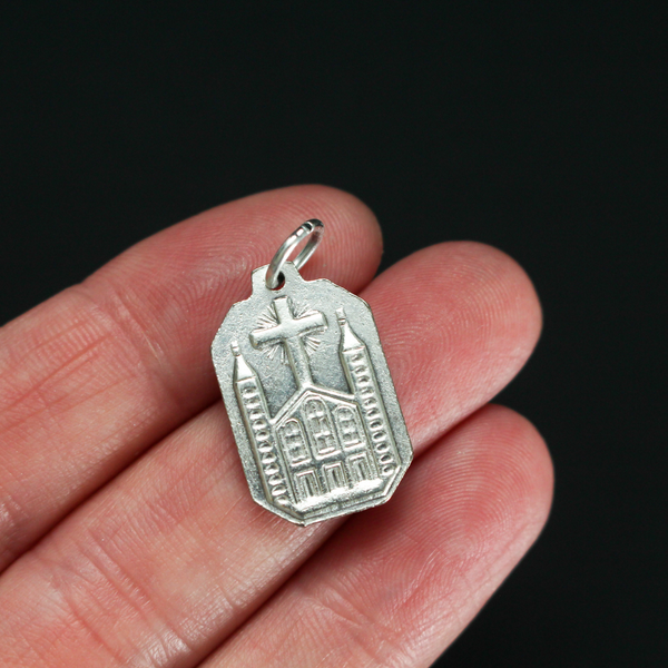 Unique shaped medal with Our Lady of Medjugorje on the front and St. James Church on the back.