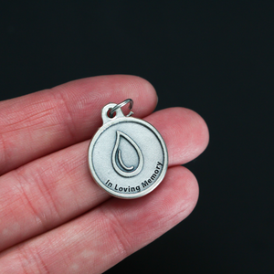 Memorial charm with a teardrop on the front with the words "In Loving Memory" beneath it. The reverse side is marked "A Tear, Lost, but never forgotten". 
