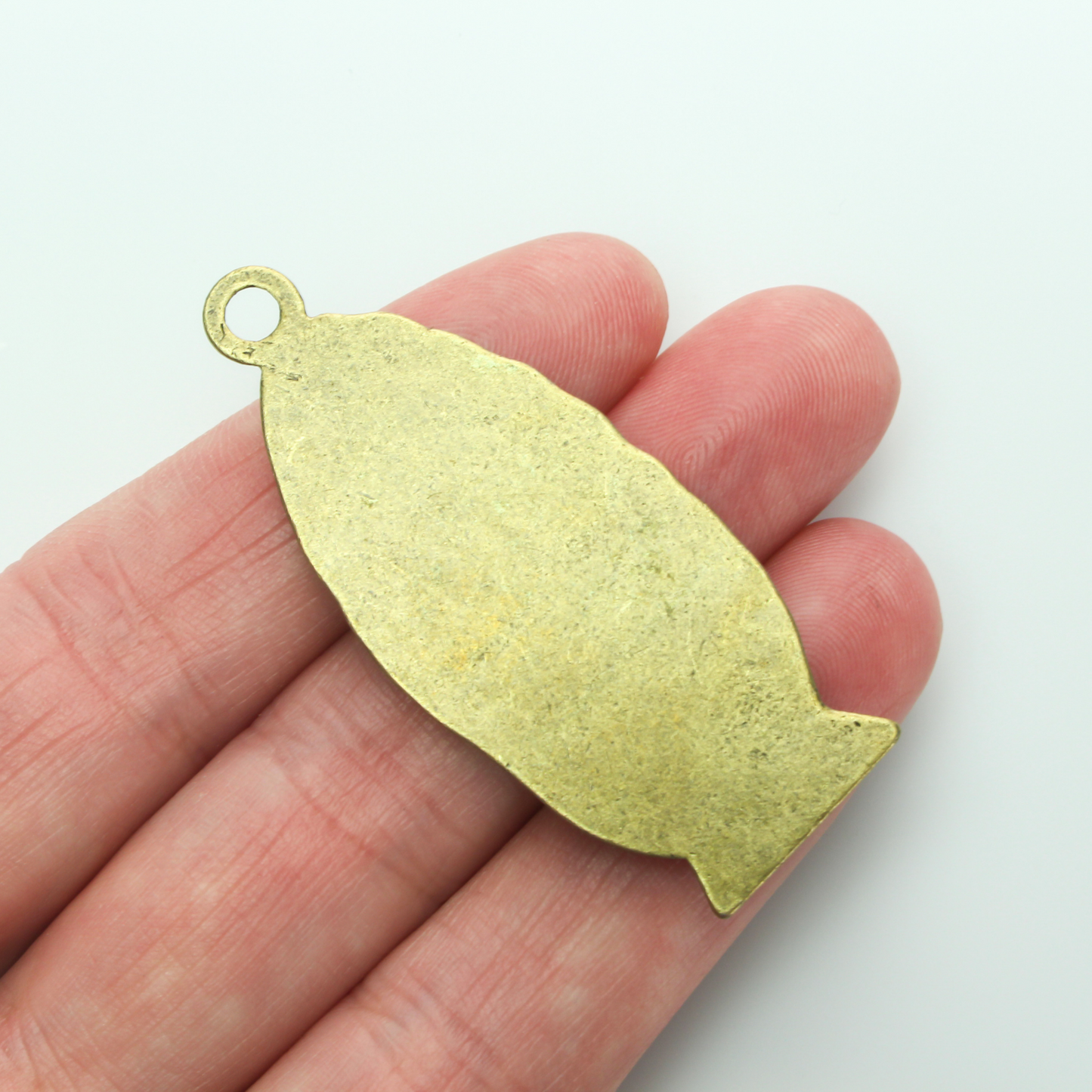A beautifully detailed pendant of Our Lady of Guadalupe. This large charm is two inches long with a flat, plain back