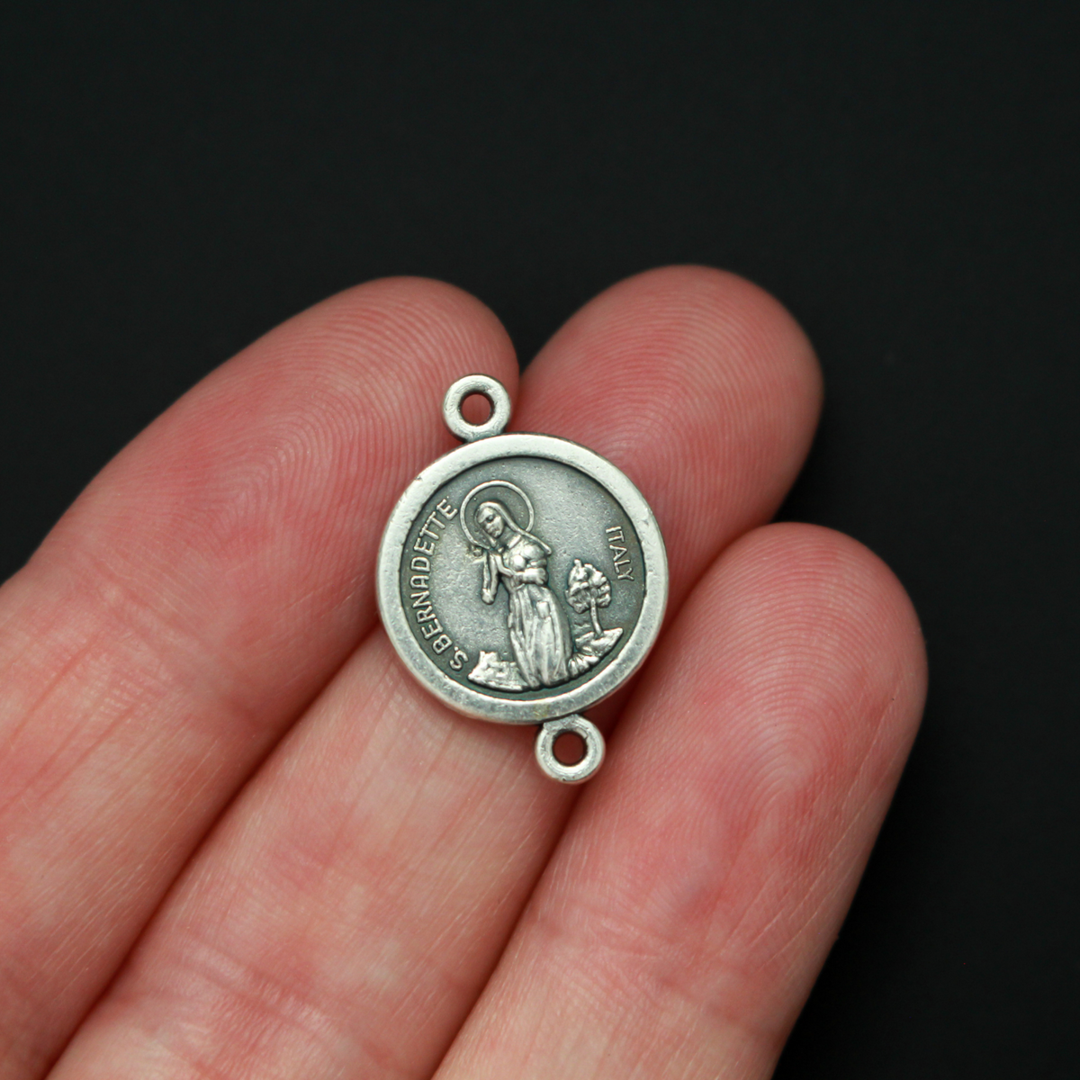 14mm St. Bernadette round flat connector links that are silver oxidized plating on a base metal