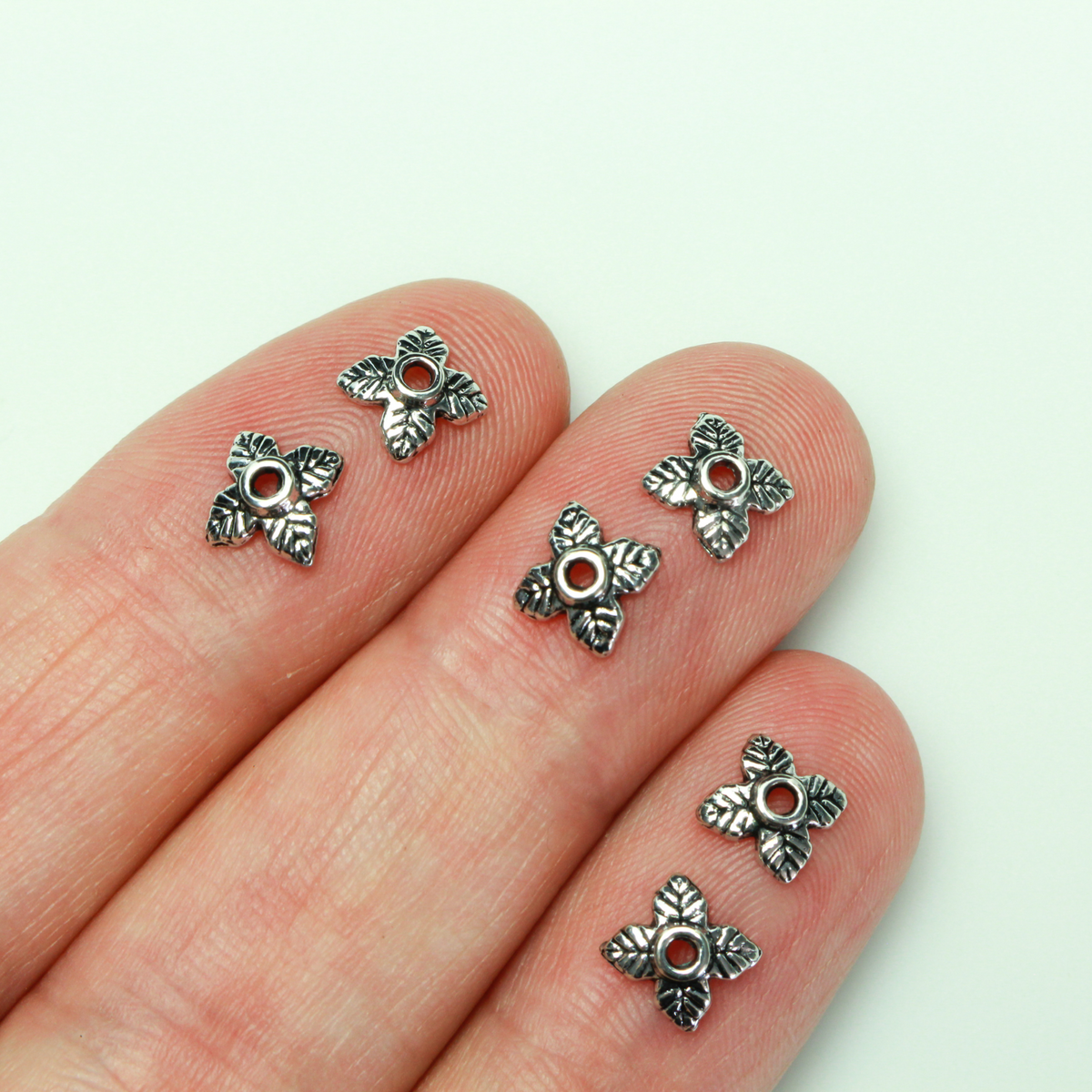 Leaf shaped bead caps with a four leaf pattern. They are 6mm with a 1mm hole