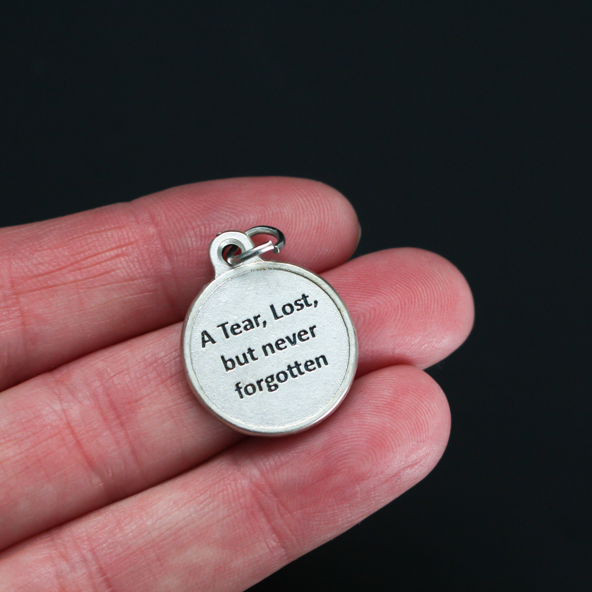 Memorial charm with a teardrop on the front with the words "In Loving Memory" beneath it. The reverse side is marked "A Tear, Lost, but never forgotten". 