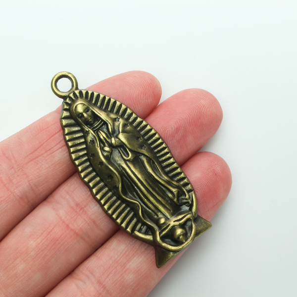 A beautifully detailed pendant of Our Lady of Guadalupe. This large charm is two inches long with a flat, plain back