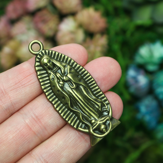 A beautifully detailed pendant of Our Lady of Guadalupe. This large charm is two inches long with a flat, plain back