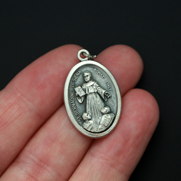 Saint Bernardine of Siena medal that depicts the saint on the front and is marked "Pray For Us" on the back