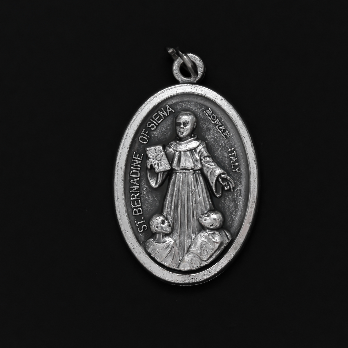 Saint Bernardine of Siena medal that depicts the saint on the front and is marked "Pray For Us" on the back