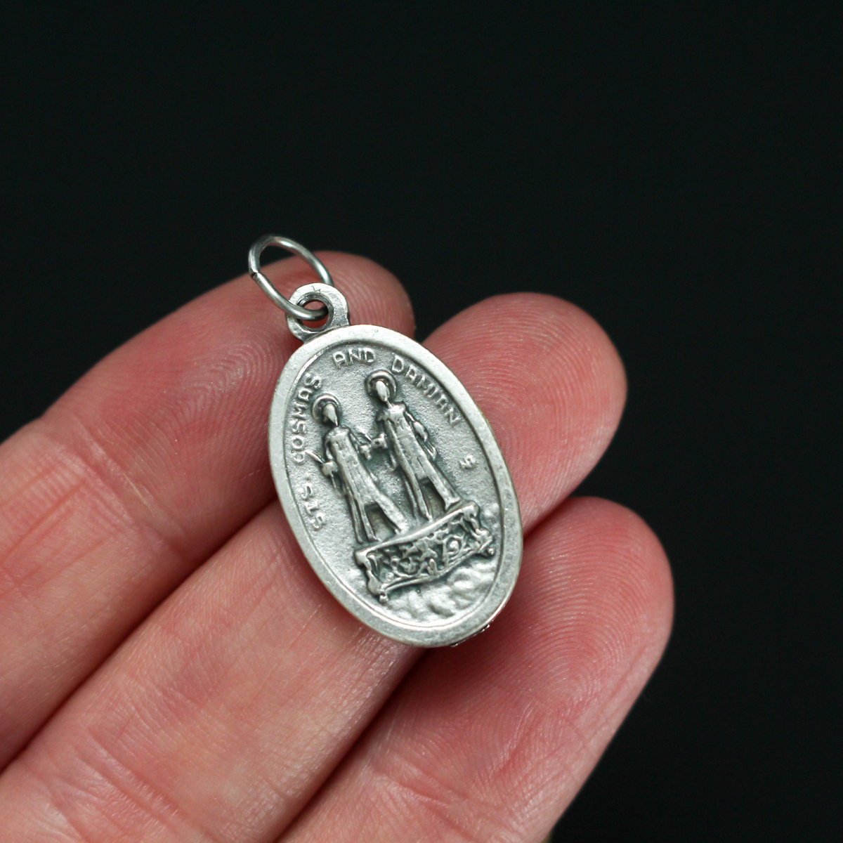 Saints Cosmas and Damian oval medal that depicts the brothers on the front and "Pray For Us" on the back