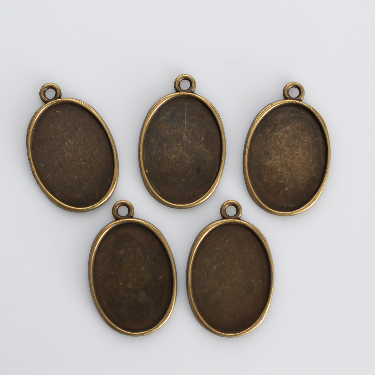 Flat oval pendant cabochon setting in an antiqued bronze tone color. This is a plain edge bezel cup with a 25mm x 18mm tray.