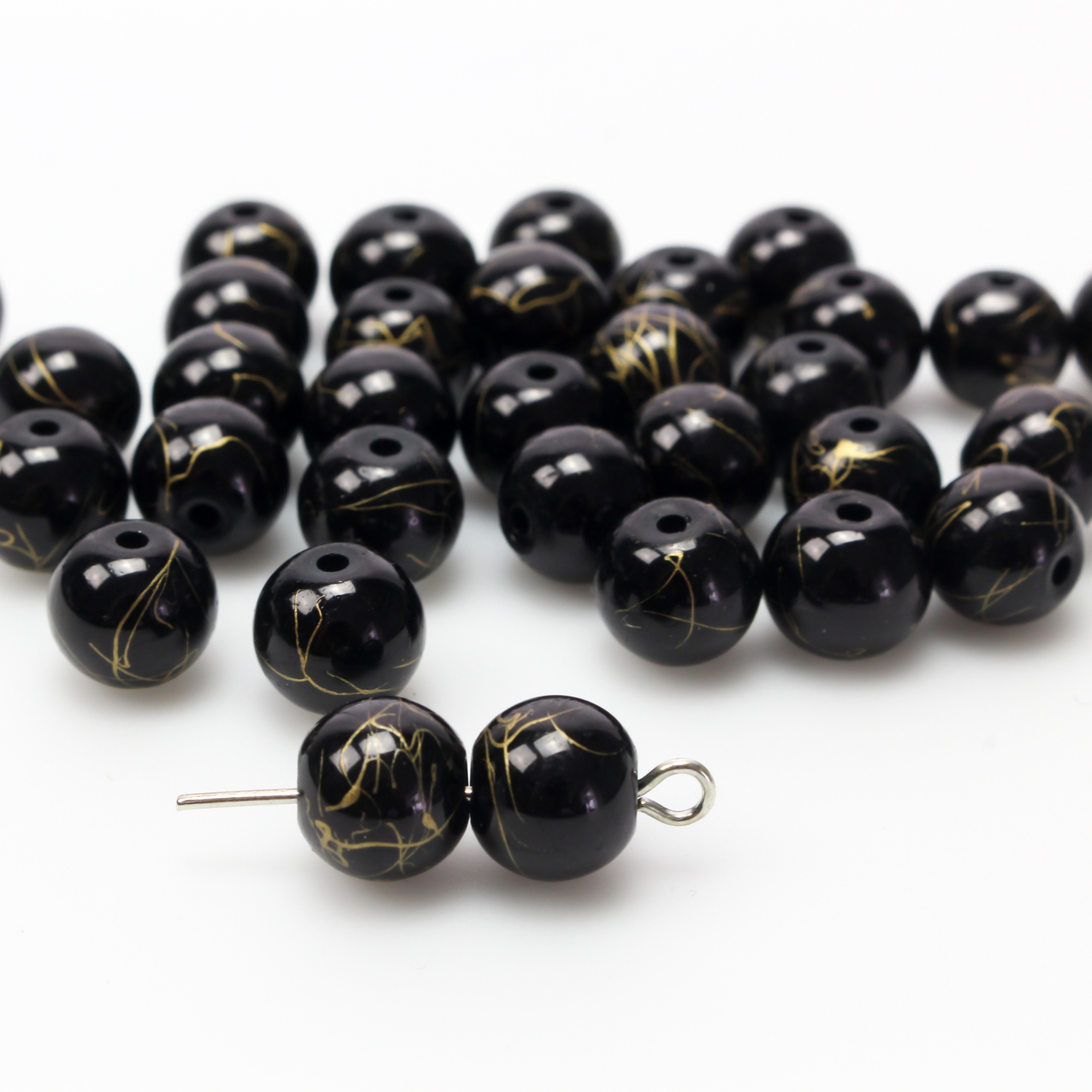 8mm Black glass beads with a gold swirl pattern. Sold in packs of 60 beads, enough to make one five-decade rosary
