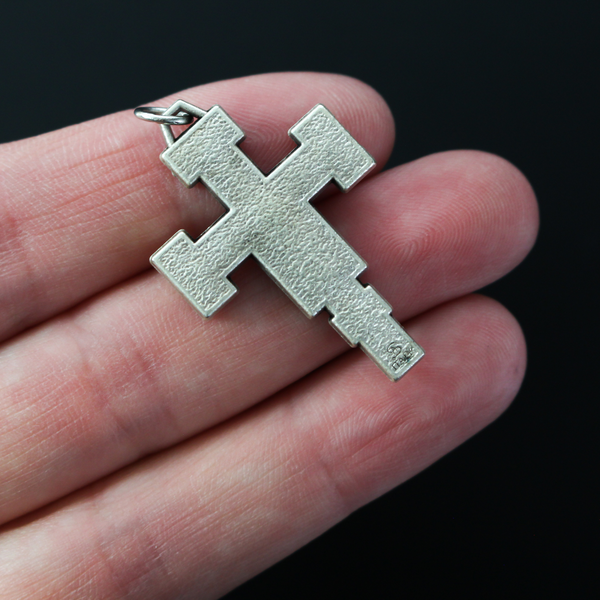 Extreme Humility Crucifix pendant. The backside has a pebbled texture and is marked "Italy" near the bottom.