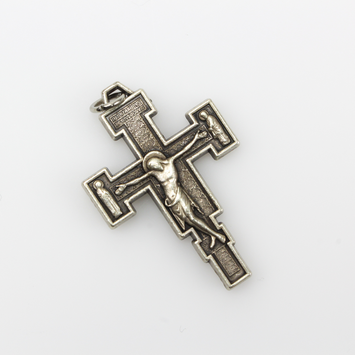 Extreme Humility Crucifix pendant. The backside has a pebbled texture and is marked "Italy" near the bottom.