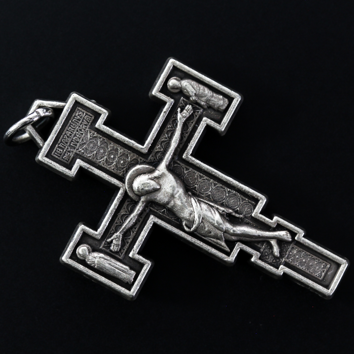Extreme Humility Crucifix pendant. The backside has a pebbled texture and is marked "Italy" near the bottom.