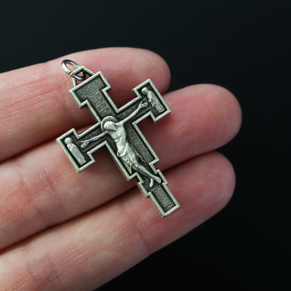 Extreme Humility Crucifix pendant. The backside has a pebbled texture and is marked "Italy" near the bottom.