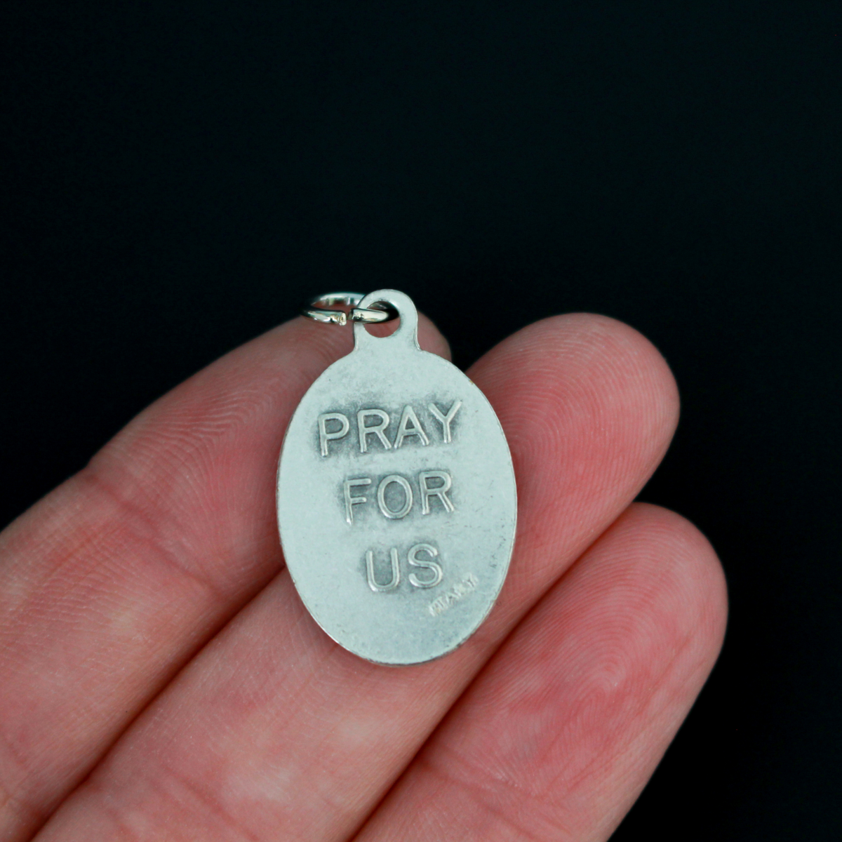 Saint John Berchmans medal. The front depicts the saint and the reverse is marked "Pray For Us".