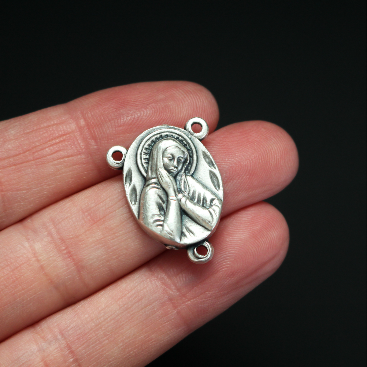 one inch long silver tone rosary centerpiece with the Blessed Virgin Mary on the front and the Sacred Heart of Jesus on the back
