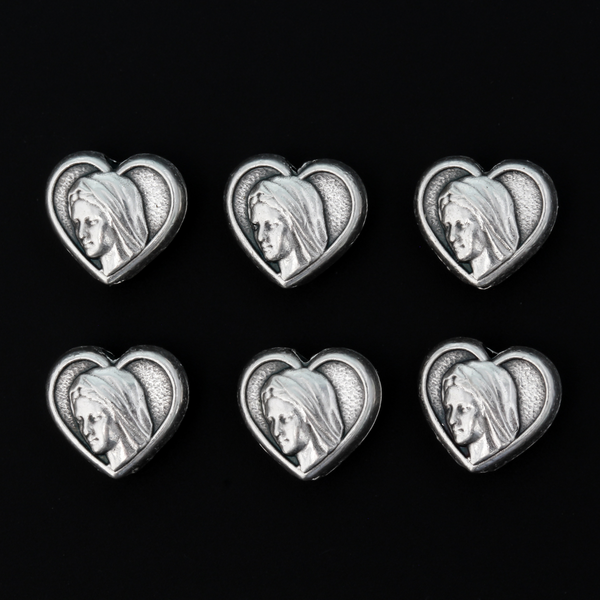 Heart shaped metal beads that features an image of Our Lady of Medjugorje on both sides.