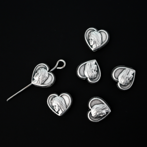 Heart shaped metal beads that features an image of Our Lady of Medjugorje on both sides.
