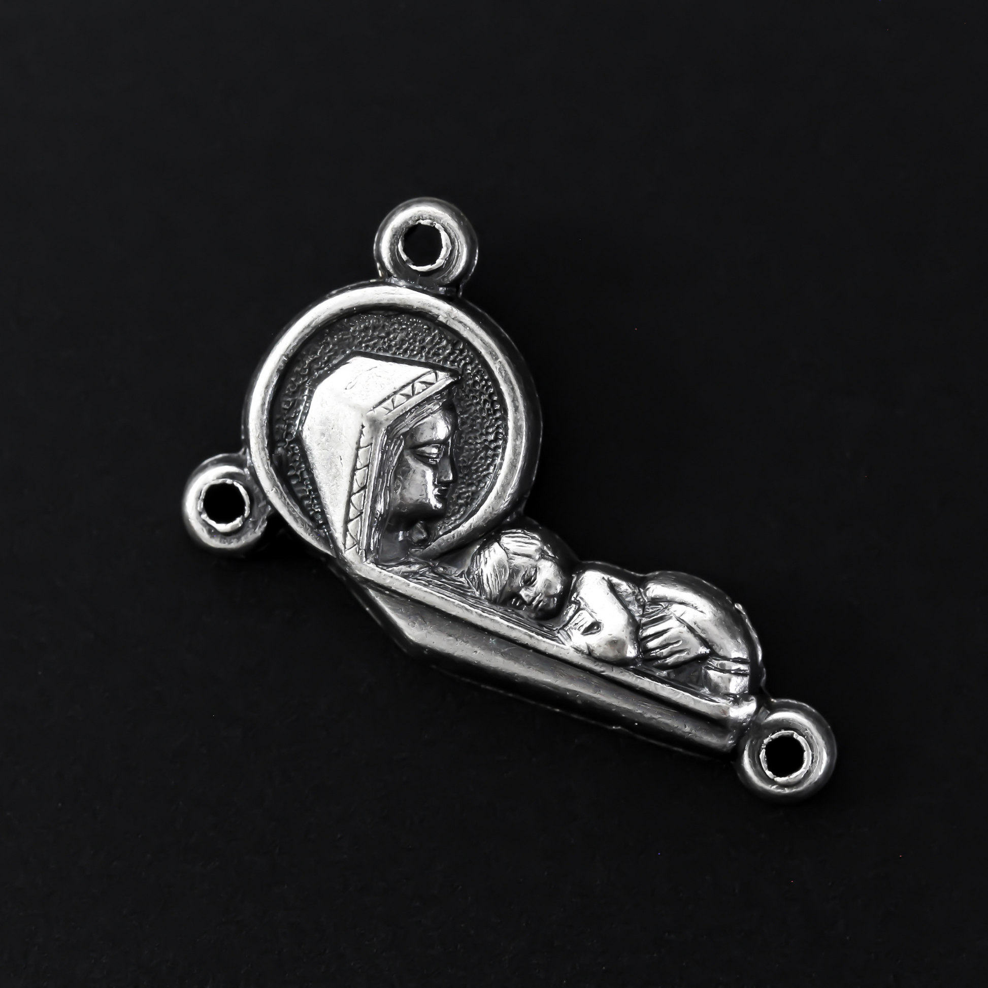 rosary centerpiece with an embossed image with a profile of our Mother Mary and the Child Jesus on the front, and an embossed image of the Sacred Heart of Jesus on the reverse