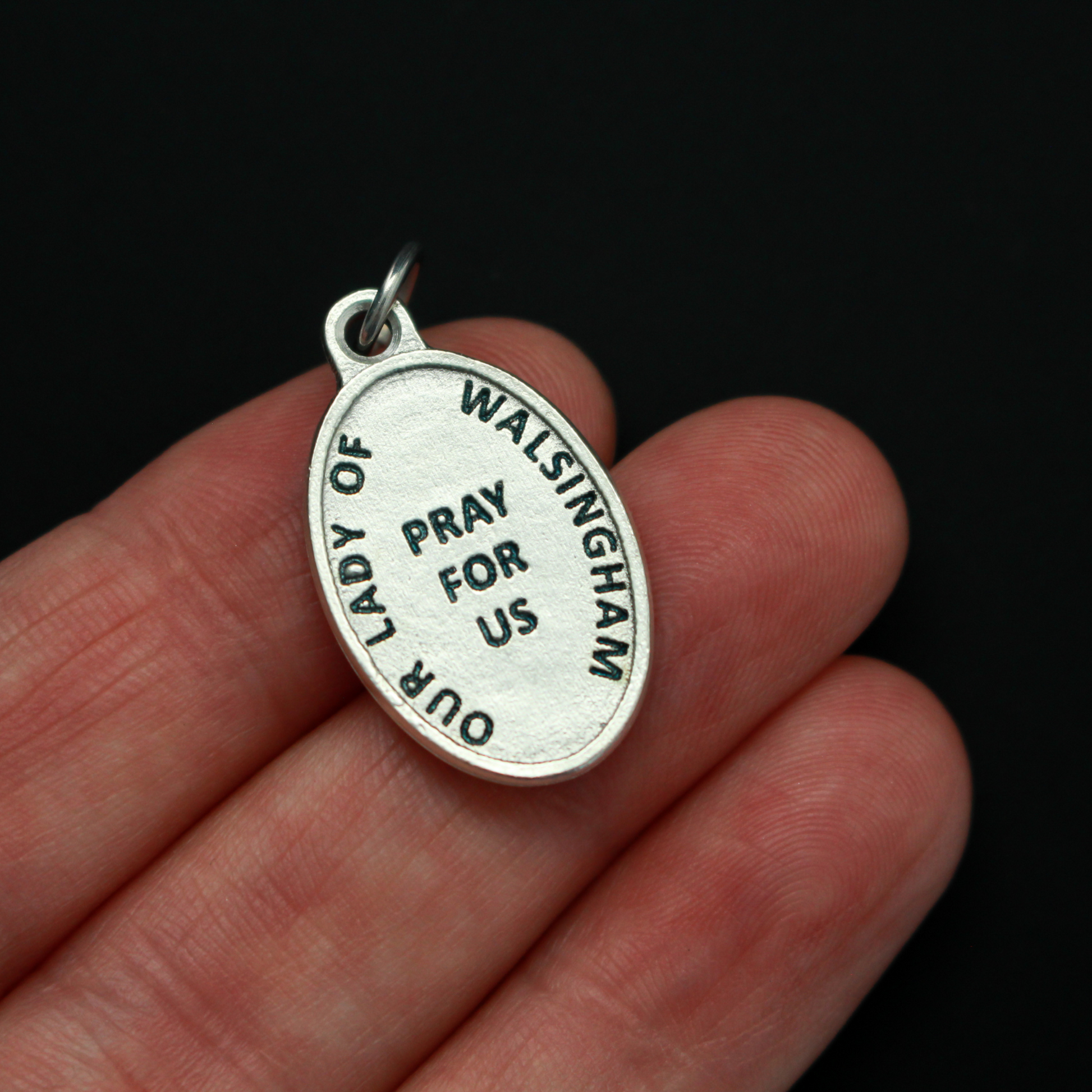 Our Lady of Walsingham medal that depicts Our Lady on the front and the words "Our Lady of Walsingham Pray For Us" on the back.