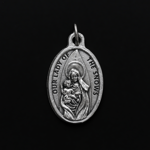 Our Lady of Snows devotional medal that is marked "Pray For Us" on the backside