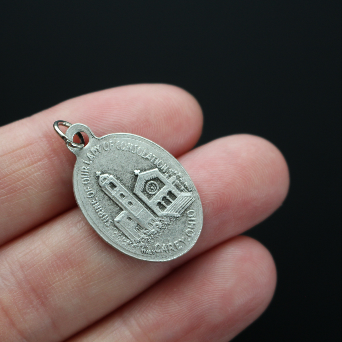 Our Lady of Consolation medal that depicts Our Lady on the front and the Shrine of Our Lady of Consolation in Carey, Ohio on the backside