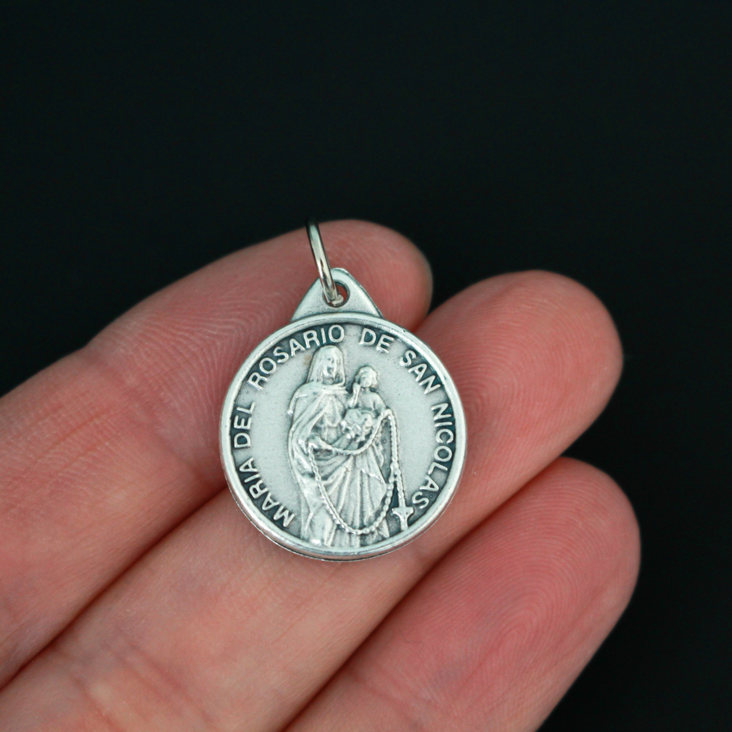 The front of the medal features an embossed image from the reported apparitions of Maria del Rosario de San Nicolas, Argentina.