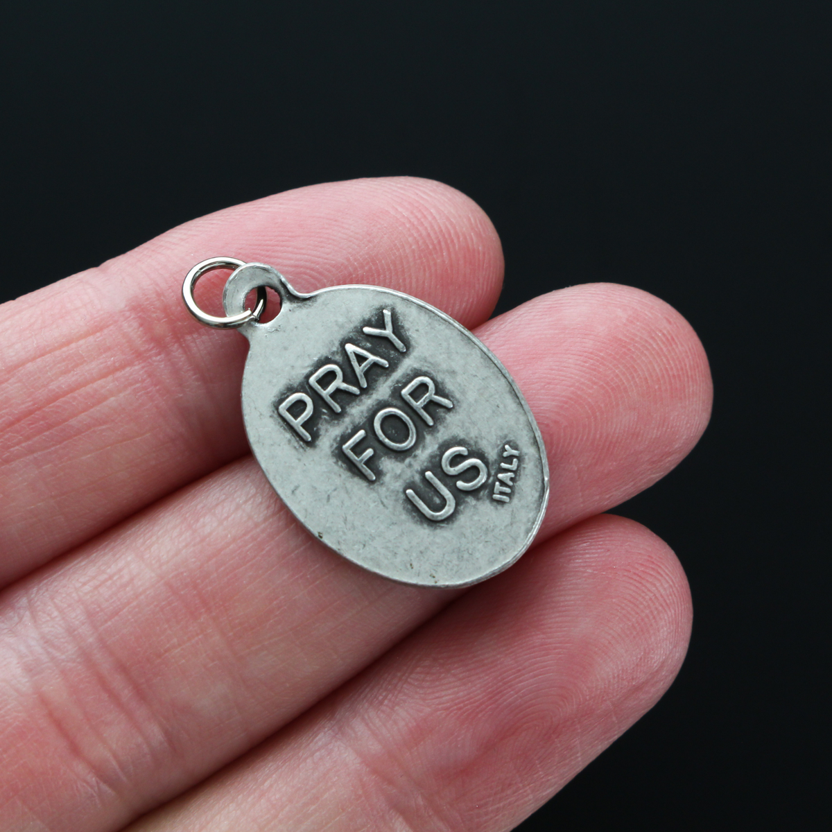 Saint Junípero Serra medal that depicts the saint on the front and "Pray For Us" on the back.