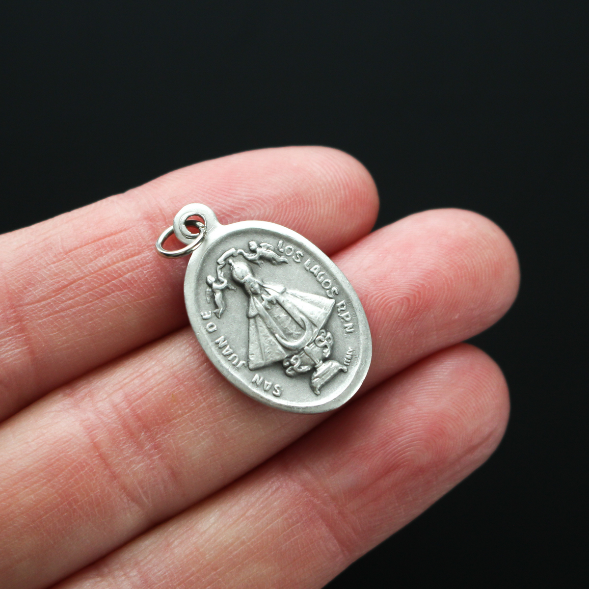 Our Lady of San Juan de Los Lagos medal that depicts the image of Our Lady on the front and the Sacred Heart of Jesus on the back
