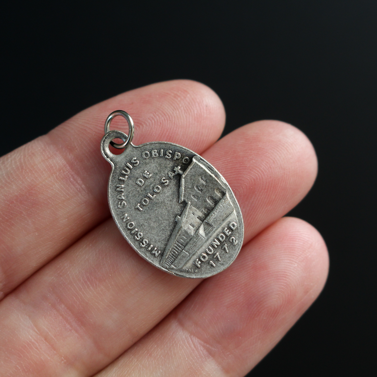 Saint Louis of Toulouse medal that depicts the saint on the front and the Mission San Luis Obispo de Tolosa on the back