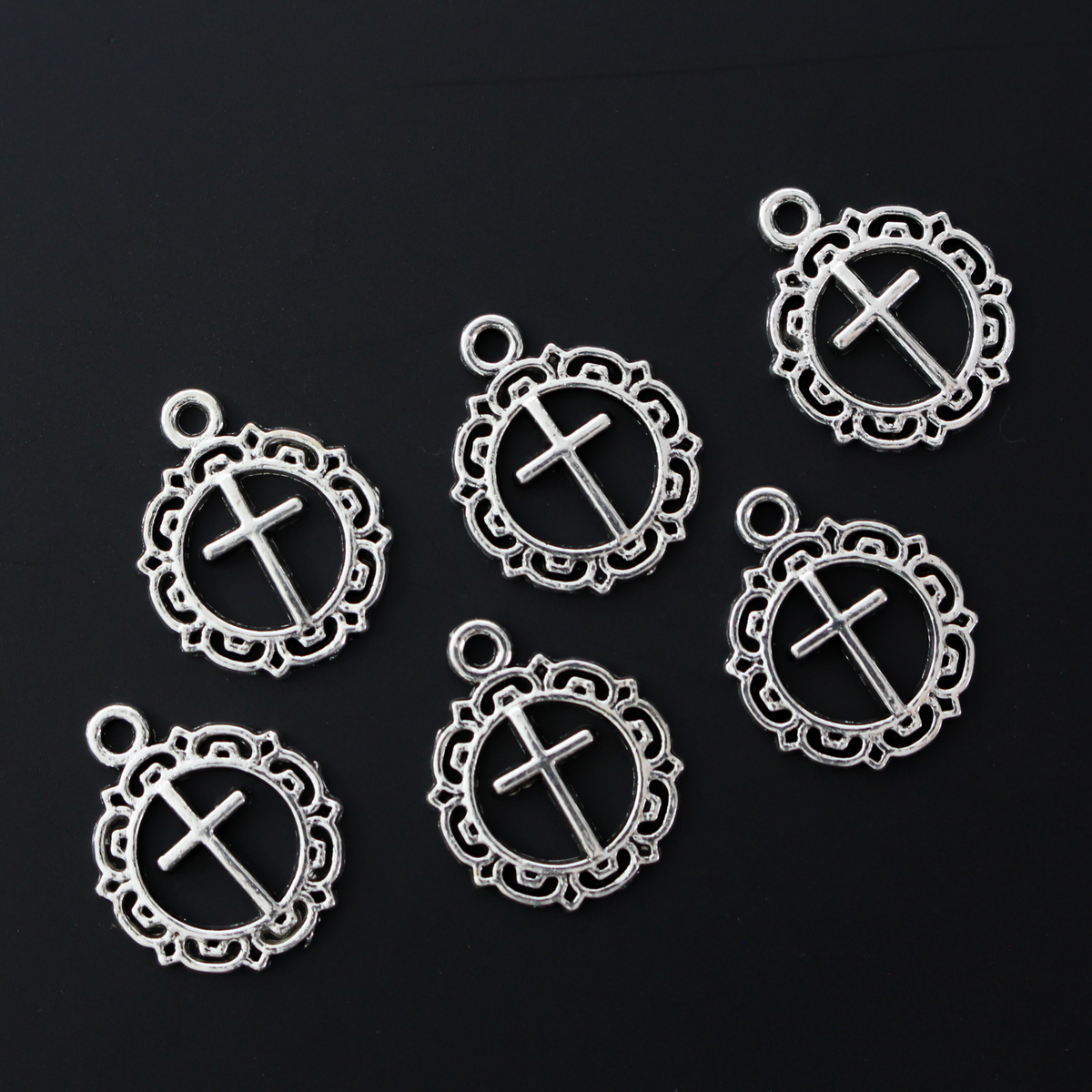 Round ornately framed cross charm in an antiqued silver-tone in color, 20mm long