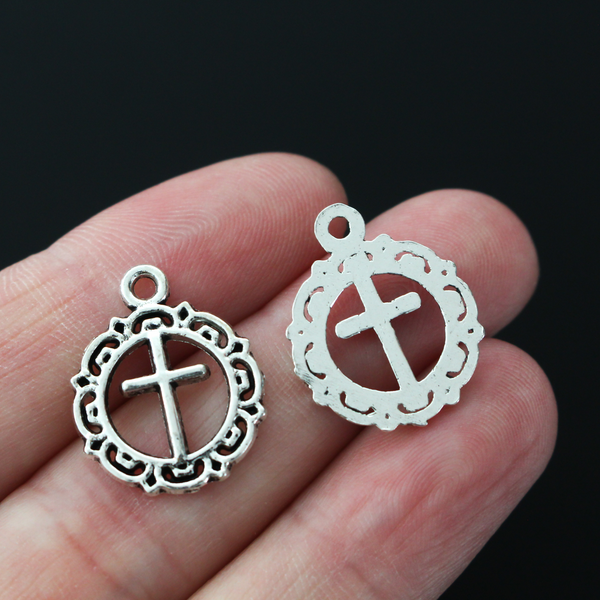 Round ornately framed cross charm in an antiqued silver-tone in color, 20mm long