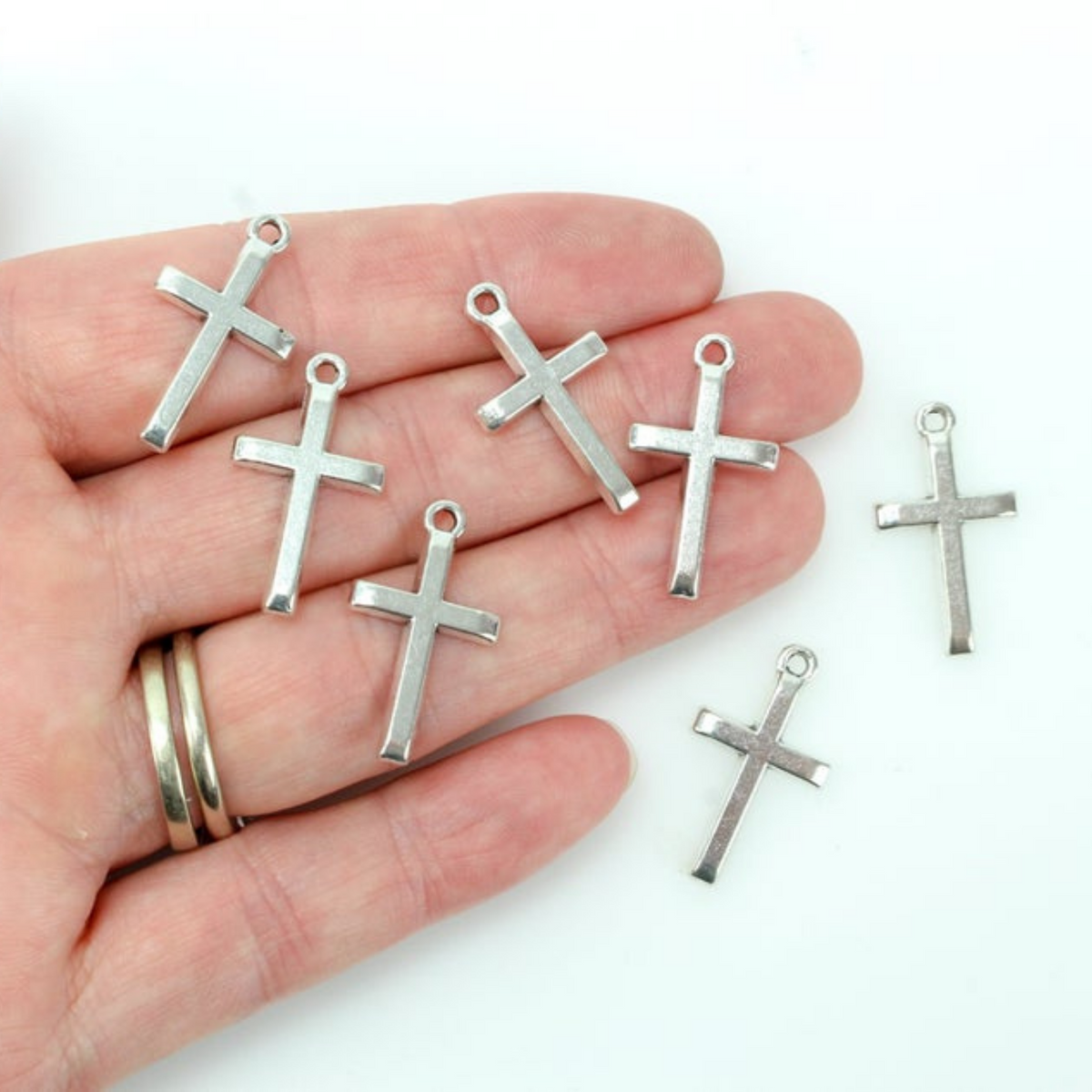 Simple silver tone cross charm with a classic design 24mm long