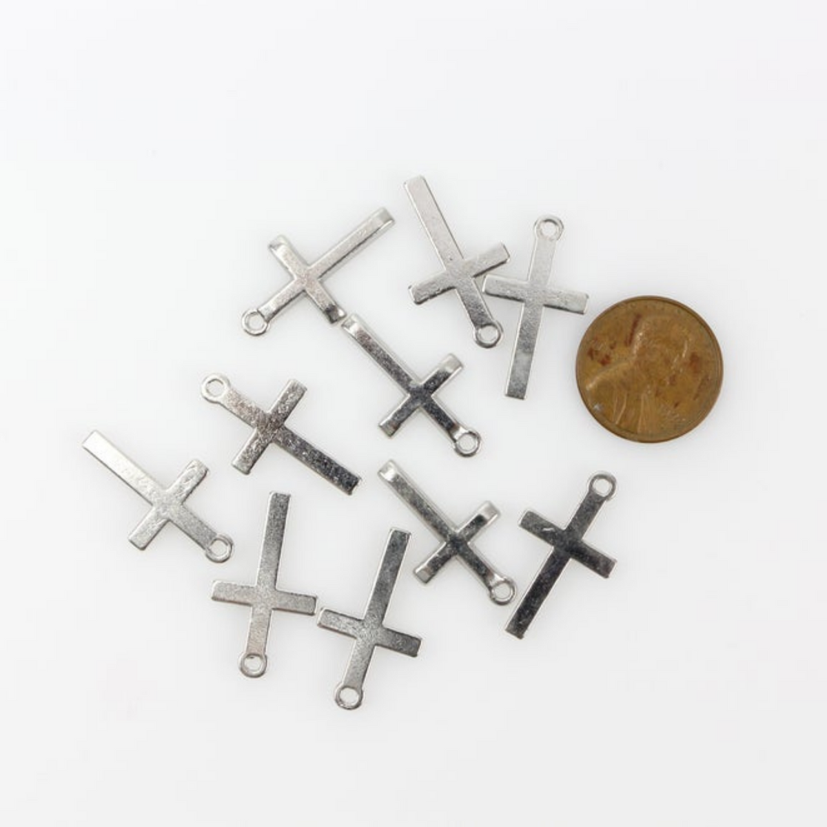 Simple silver tone cross charm with a classic design 24mm long