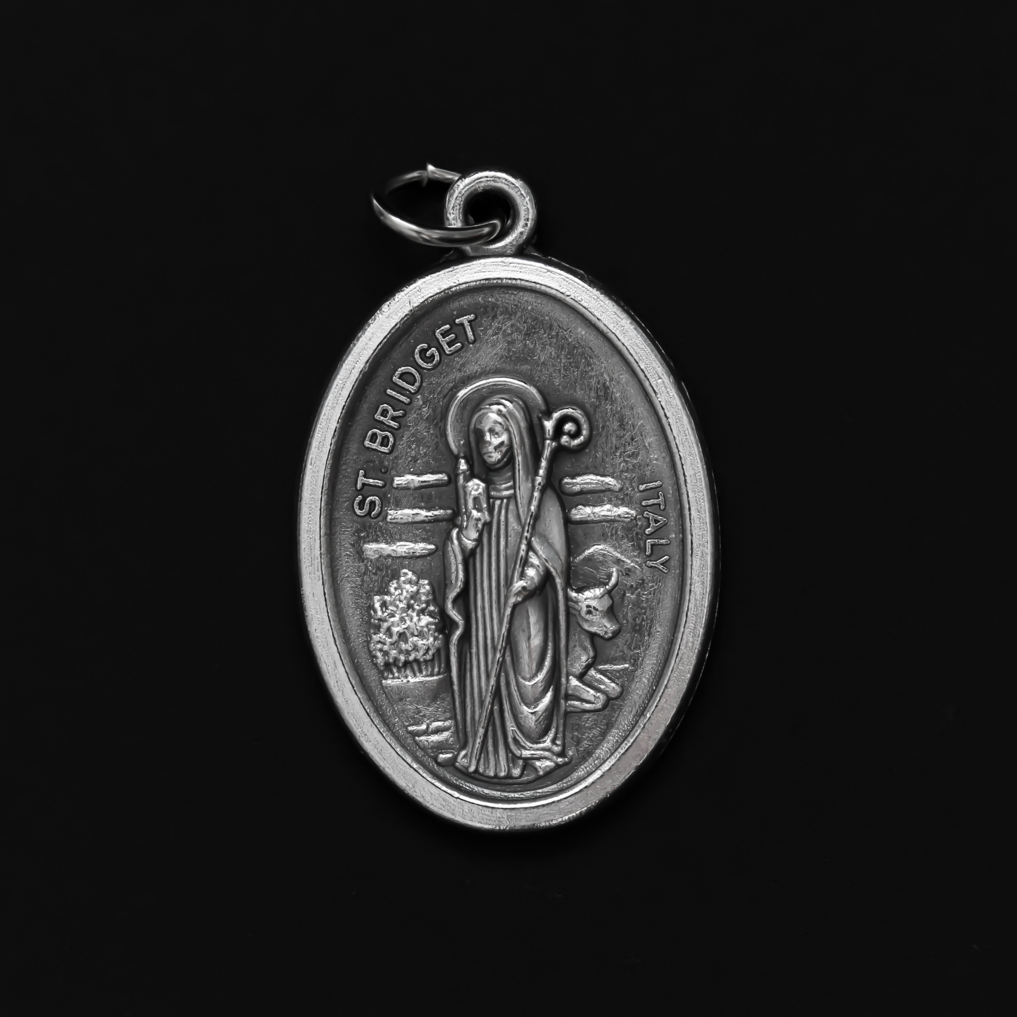 St. Bridget (Brigid) oval medal that depicts the saint on the front and "Pray For Us" on the back.