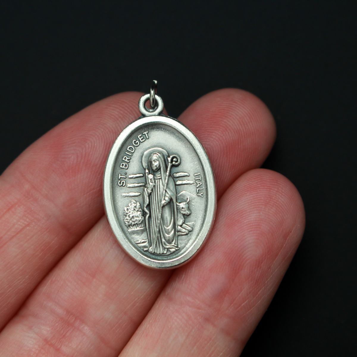 St. Bridget (Brigid) oval medal that depicts the saint on the front and "Pray For Us" on the back.