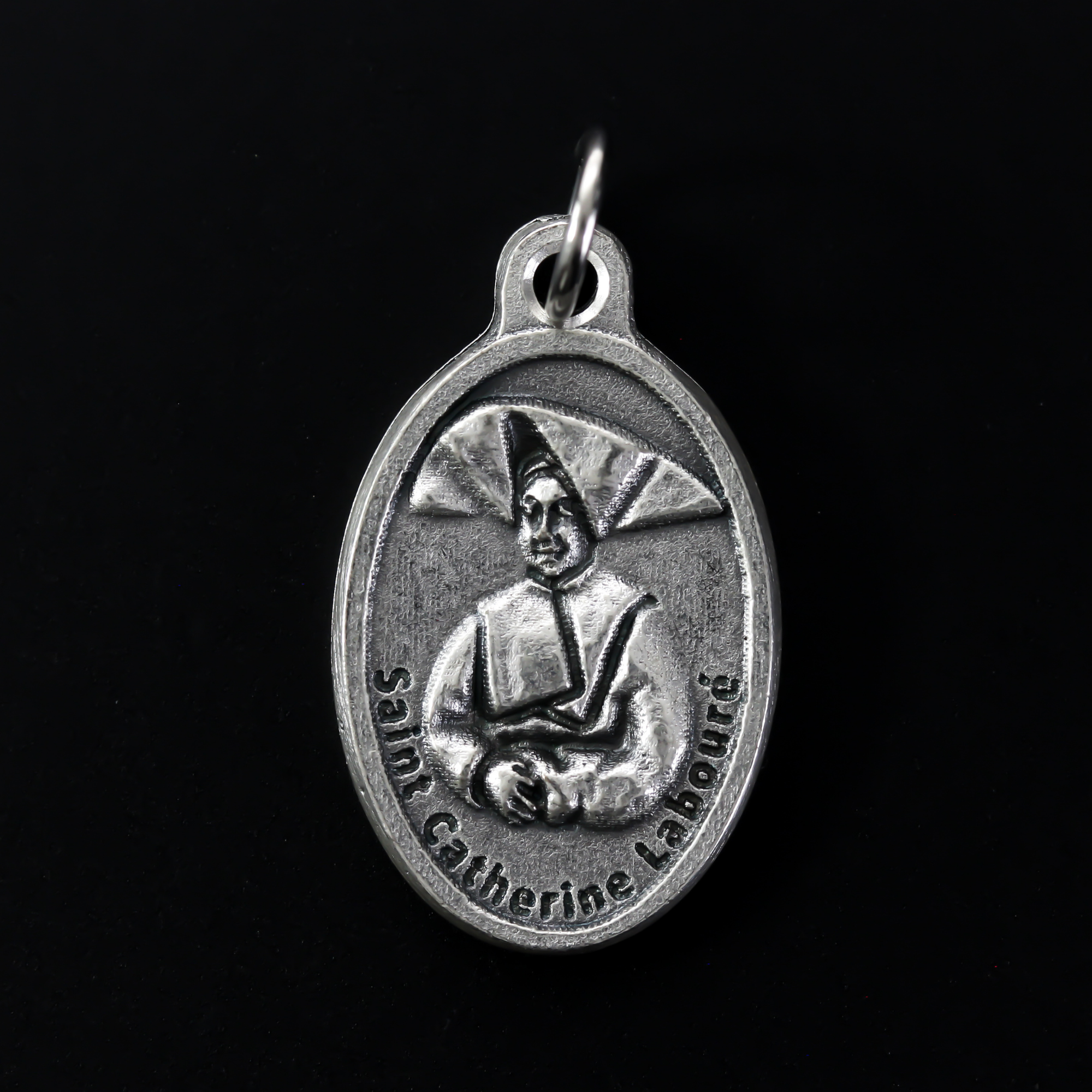 Saint Catherine Labouré medal that depicts the saint on the front and the reverse is marked "Pray For Us".