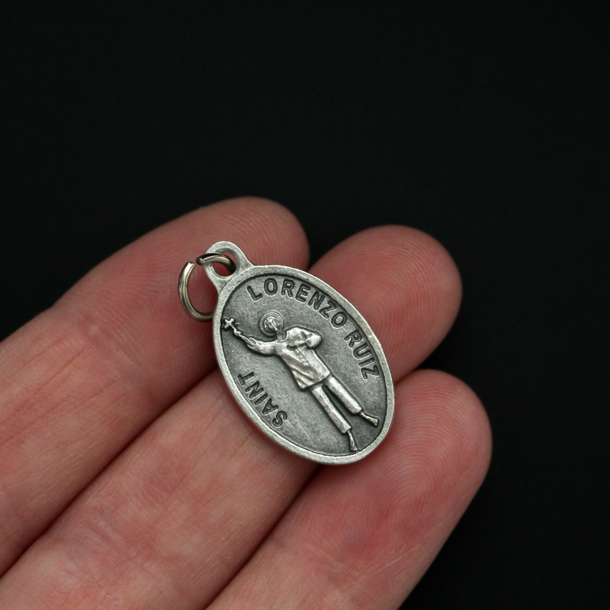 Saint Lorenzo Ruiz medal that depicts the saint on the front and is marked "Pray For Us" on the back