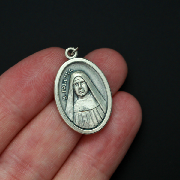 Saint Pauline medal that depicts the saint on the front and "Pray For Us" on the back