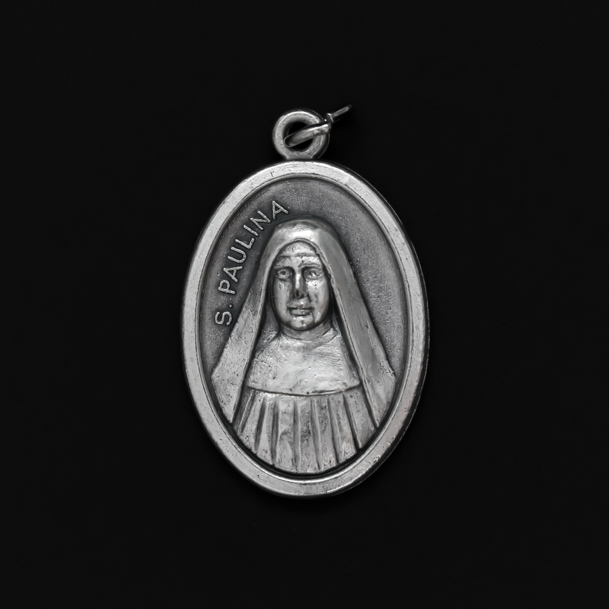 Saint Pauline medal that depicts the saint on the front and "Pray For Us" on the back