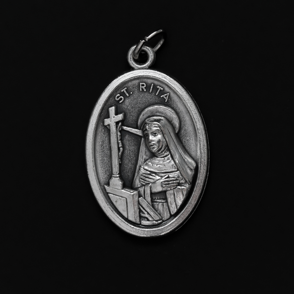 Saint Rita medal that depicts the saint on the front and "Pray For Us" on the back