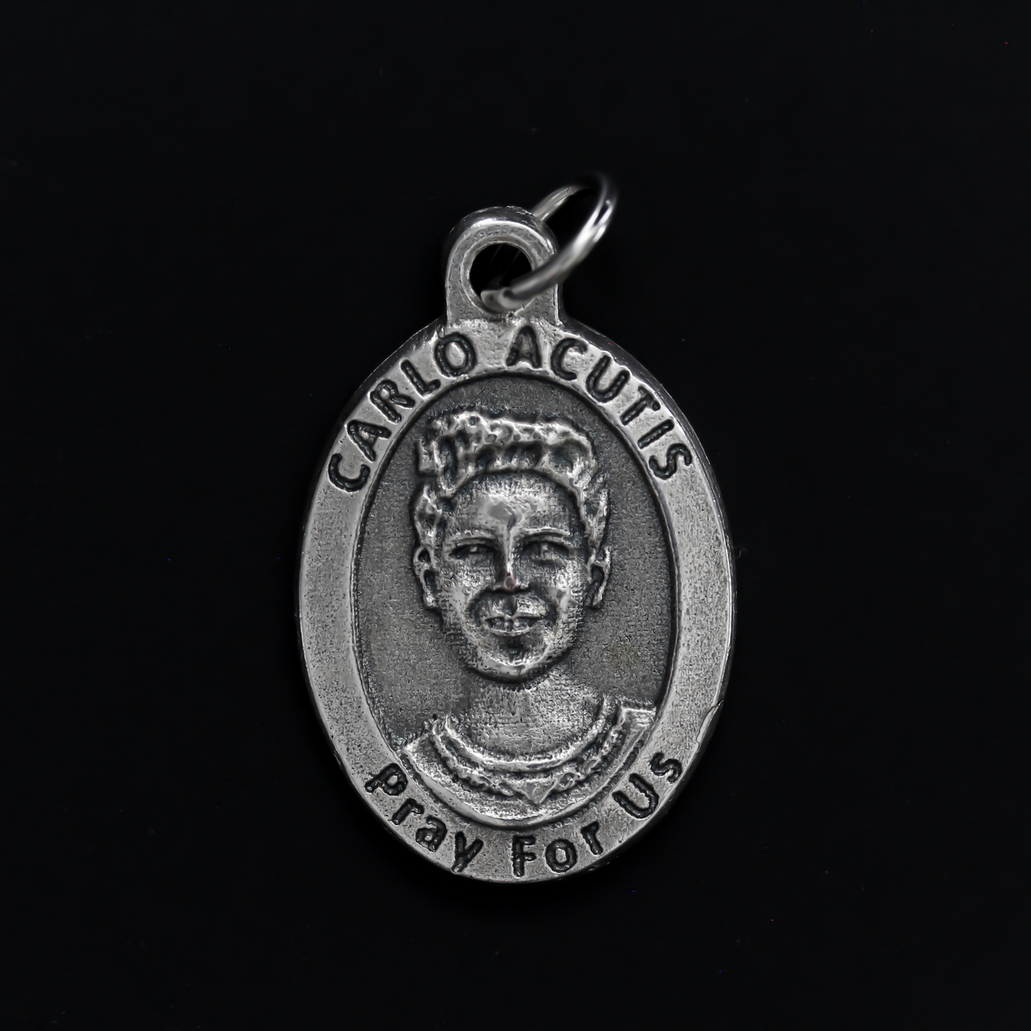 Venerable Carlo Acutis medal that depicts the saint on the front and the symbols of the Eucharist on the back